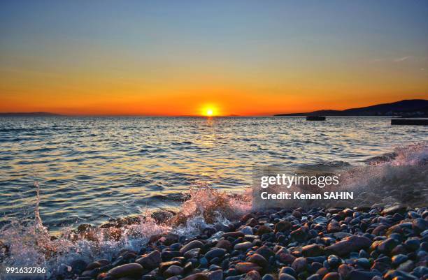 superb trio: sunset, waves and stones - superb stock pictures, royalty-free photos & images