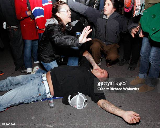 Fan lays on the ground after suffering the effects of tear gas released by police as fans celebrated in downtown Montreal after the Montreal...