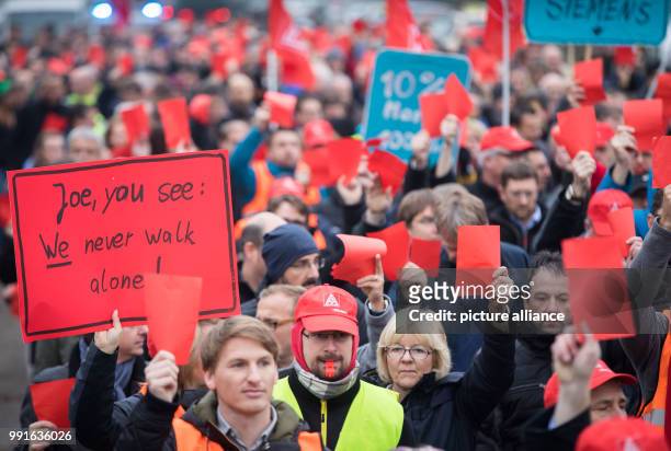 Employees of German industrial conglomerate Siemens' Offenbach branch hold red cards for Siemens head Joe Kaeser during a protest against the plant's...