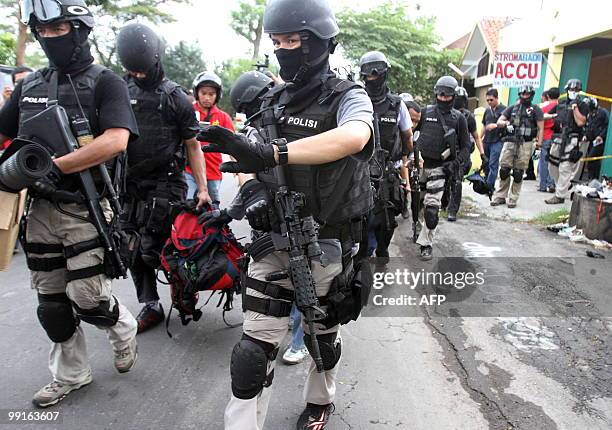 Indonesian anti-terror policemen from Densus 88 carry evidence from a shop during a raid in Baki, Solo, on May 13, 2010. Three terrors suspects were...