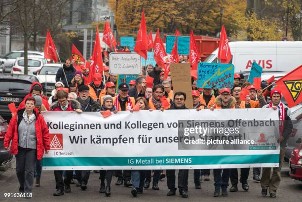 Employees of German industrial conglomerate Siemens' Offenbach branch hold placards and banners as they take part in a during a protest against the...