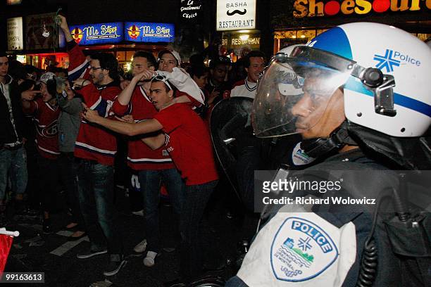 Montreal police riot police watch as fans celebrate in the streets of downtown Montreal after the Montreal Canadiens defeated the Pittsburgh Penguins...