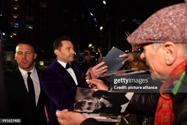 Australian actor Hugh Jackman sign autographs as he arrives to attend the awards ceremony of the 69th edition of the Bambi media prize in Berlin,...