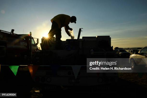 Aaron Miller, a firefighter from Caldwell, Idaho, puts ice in a cooler on his brush truck at the spike camp before heading out on the Spring Creek...