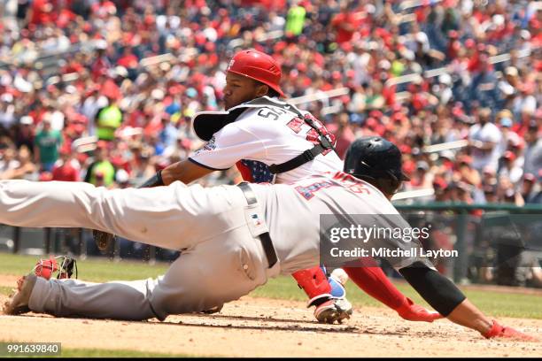 Rafael Devers of the Boston Red Sox beats the tag by Pedro Severino of the Washington Nationals on a Jackie Bradley Jr. #19 , sac fly in seventh...