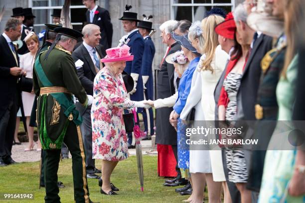 Britain's Queen Elizabeth II meets guests as she hosts the annual garden party at the Palace of Holyroodhouse in Edinburgh on July 4, 2018.