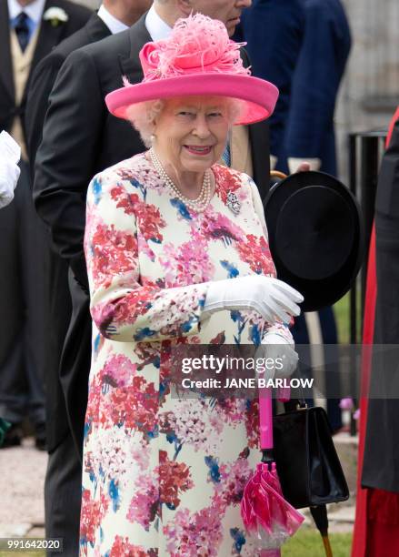 Britain's Queen Elizabeth II meets guests as she hosts the annual garden party at the Palace of Holyroodhouse in Edinburgh on July 4, 2018.