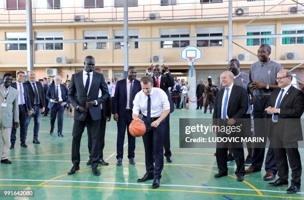 French President Emmanuel Macron throws the ball during a meeting with former pro basketball players from NBA Africa and takes part in a training...