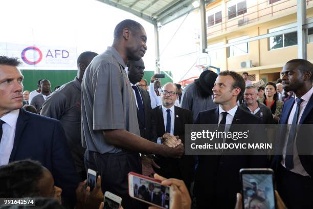 French President Emmanuel Macron greets former pro basketball player from NBA Africa in the French Louis Pasteur high school on July 4 in Lagos.