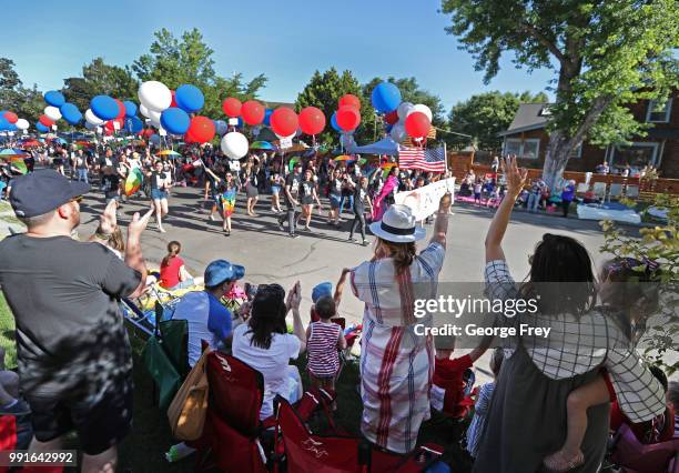 Spectators wave to members of the LGBT youth support group "Encircle", as they march down Center Street in the Provo Freedom Festival Pre-Parade on...
