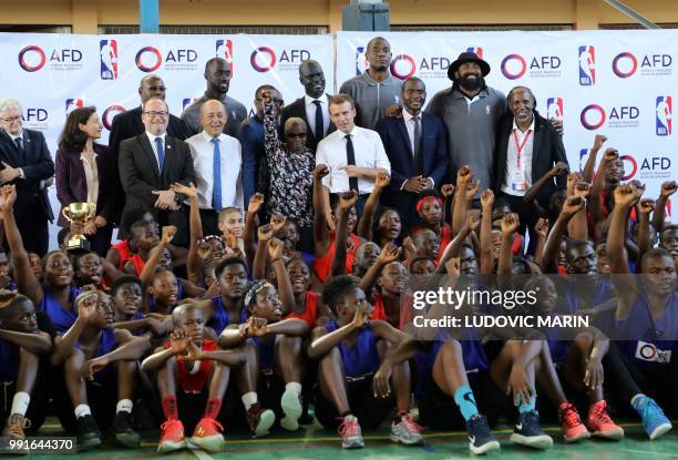 French President Emmanuel Macron poses for a familly photo with former pro basketball players from NBA Africa and young basketball players in the...