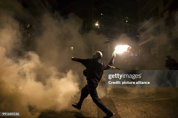 Demonstrator throws a Molotov cocktail towards Greek Riot Police during clashes following a protest against state repression on the 44th anniversary...