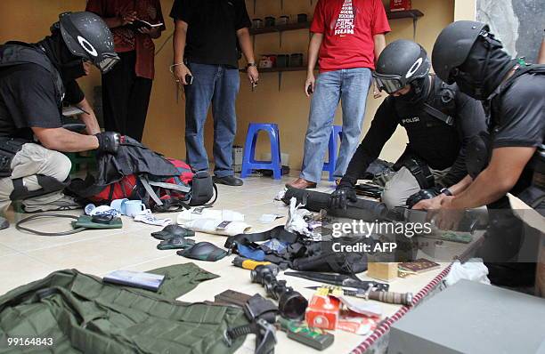 Indonesian anti-terror policemen from Densus 88 check evidence during a raid at a shop in Baki, Solo, in Central Java on May 13, 2010. Three terrors...
