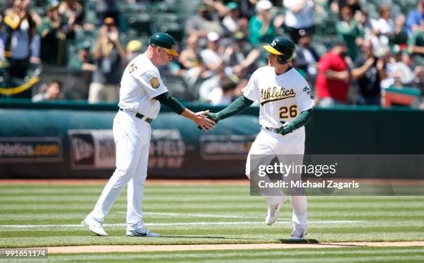Matt Chapman of the Oakland Athletics is congratulated by Third Base Coach Matt Williams while running the bases after hitting a home run during the...