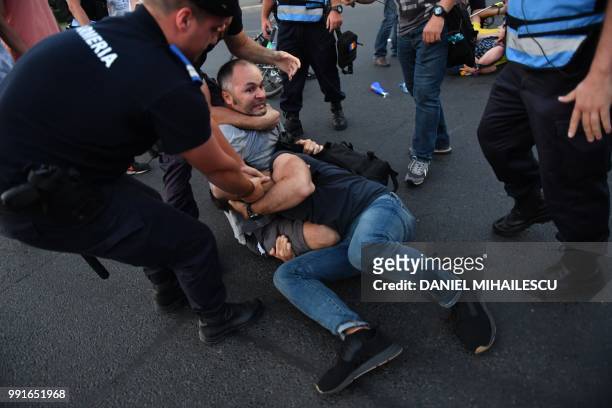 Protesters are removed by police during a protest in front of the Romanian Government headquarters in Bucharest July 4, 2018. - Romania's parliament...