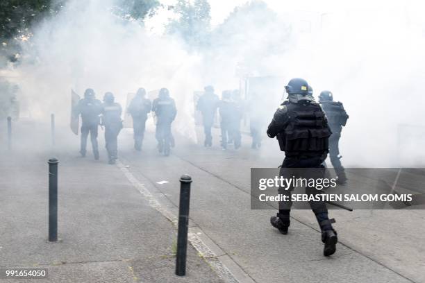 French gendarmes run through the tear gas smoke at the Breil neighbourhood in Nantes, on July 4, 2018. Groups of young people clashed with police in...