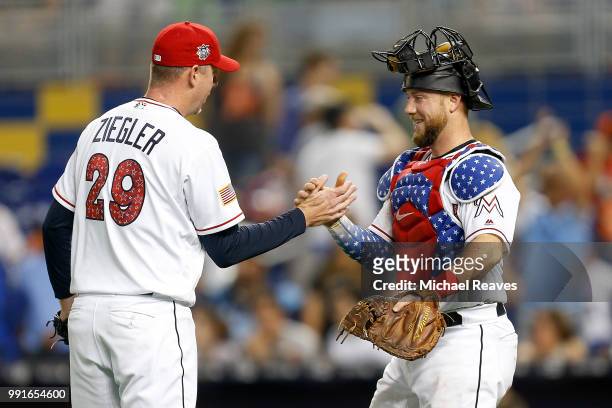 Brad Ziegler of the Miami Marlins celebrates with Bryan Holaday after they defeated the Tampa Bay Rays 3-0 at Marlins Park on July 4, 2018 in Miami,...