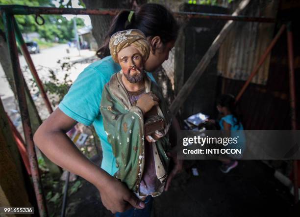 Woman and a girl salvage a few belongings which were spared by the fire that burnt down the house of opposition student leader Yubrank Suazo amid the...