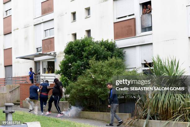 People react after French gendarmes throw tear gas on residents at the Breil neighbourhood in Nantes, on July 4, 2018. Groups of young people clashed...