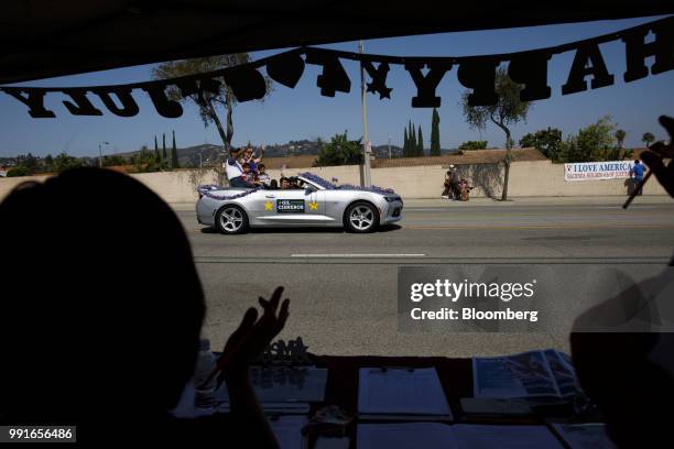 Gil Cisneros, Democratic U.S. Representative candidate from California, waves while riding in a car with his wife and sons during a Fourth of July...