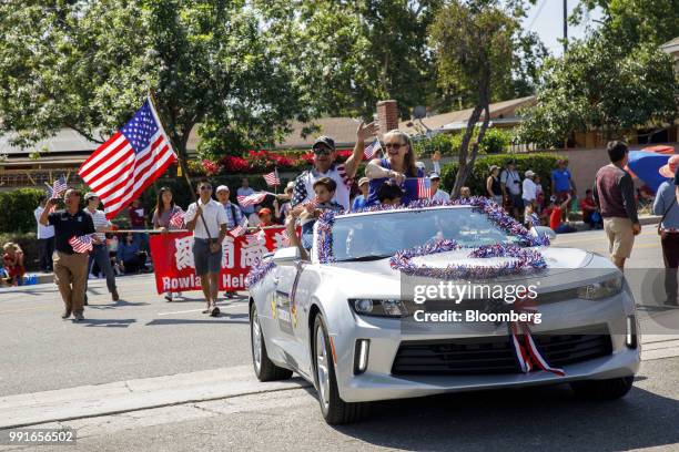 Gil Cisneros, Democratic U.S. Representative candidate from California, center, waves while riding in a car with his wife and sons during a Fourth of...