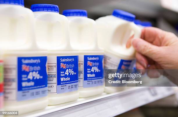 Customer takes a pint of milk from the shelf at a Sainsbury's supermarket in Chafford Hundred, U.K., on Wednesday, May 13, 2010. The U.K.'s third...