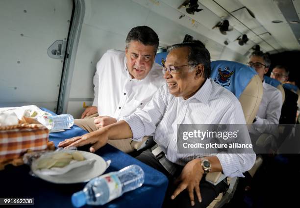 German Foreign Minister Sigmar Gabriel speaks with his Bangladeshi counterpart, Abul Hassan Mahmud Ali onboard a helicopter taking them to the...