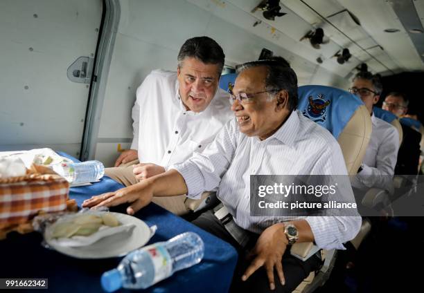 German Foreign Minister Sigmar Gabriel speaks with his Bangladeshi counterpart, Abul Hassan Mahmud Ali onboard a helicopter taking them to the...