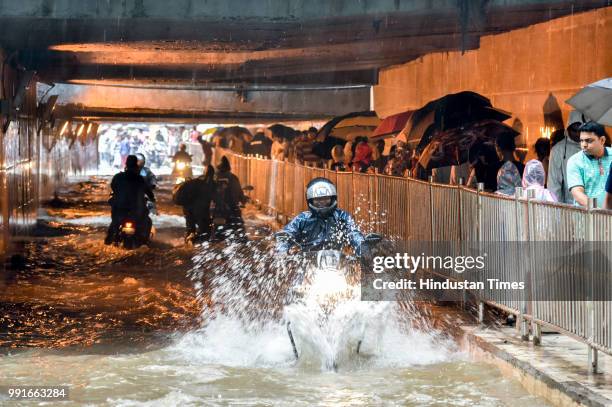 Vehicles wade through knee deep water-logged street at Khar after heavy rains on July 3, 2018 in Mumbai, India. Heavy rains for over past 16 hours...