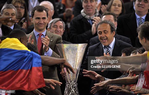 President Michel Platini hands over the trophy to Aletico Madrid's players after the final football match of the UEFA Europa League Fulham FC vs...
