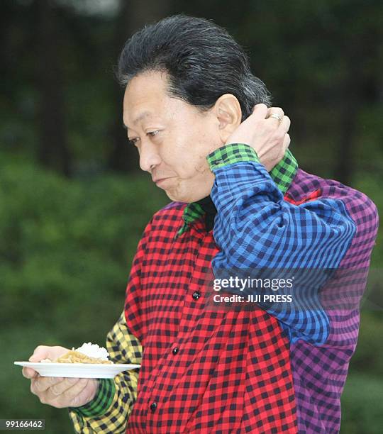In a picture taken on April 4 Japanese Prime Minister Yukio Hatoyama scratches his neck during a meet-the-people barbecue clad in a multi-coloured...