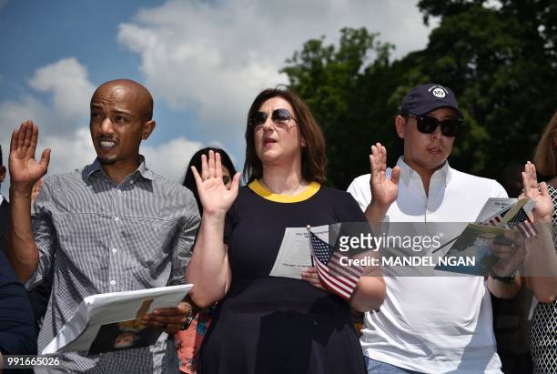 Citizenship candidates take the Oath of Allegiance in a naturalization ceremony at George Washington's Mount Vernon estate during Independence Day...