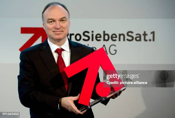 The CEO of the ProSiebenSat.1 Media AG, Thomas Ebeling, holds the logo of the channel group in his hands after the annual press conference in the...