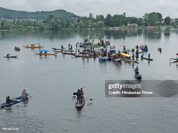 People in Shikara boats look for bodies of two men who had drowned after their boat with five on board capsized on Tuesday evening in Nigeen Lake, on...