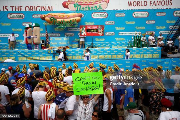Man holds a banner during the 2018 Nathan's Famous International Hot Dog Eating Contest at Coney Island in the Brooklyn borough of New York City,...