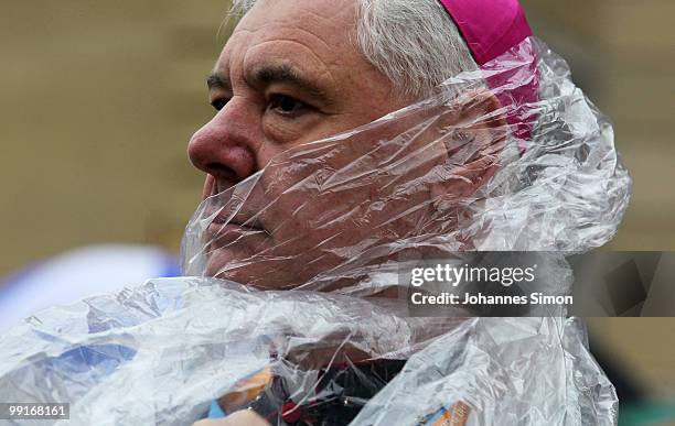 Gerhard Ludwig Mueller, Catholic bishop of Regensburg struggles with his rain cape ahead of the central ecumenical mass of the 2nd Ecumenical Church...