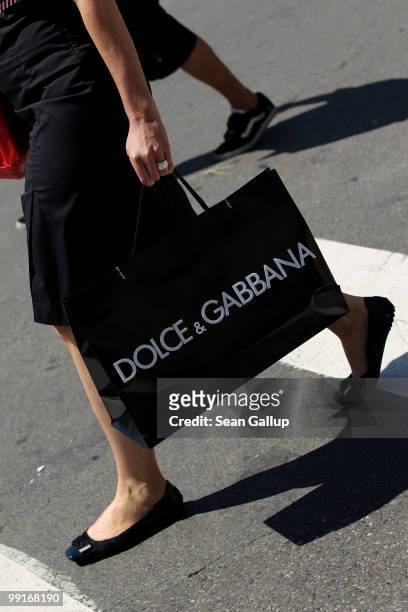 Woman carrying a Dolce & Gabbana shopping bag walks along the Croisette during the 63rd Cannes Film Festival on May 13, 2010 in Cannes, France....