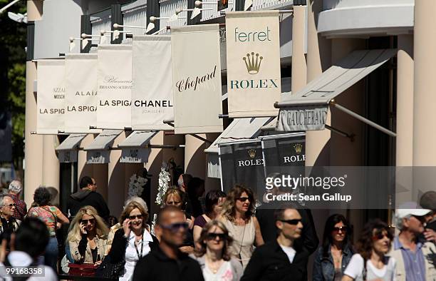 People walk past luxury stores along the Croisette during the 63rd Cannes Film Festival on May 13, 2010 in Cannes, France. Shopping and luxury brands...