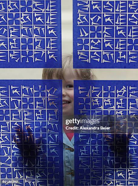 Girl looks through the window of the Herz Jesu church after a holy mass at the second day of the 2nd ecumenical Kirchentag on May 13, 2010 in Munich,...