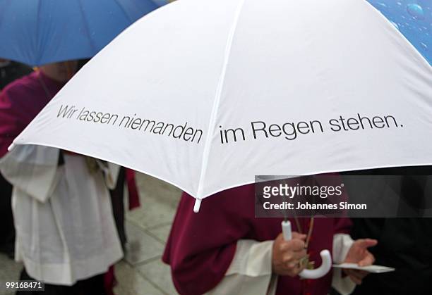 Catholic priest holods an umbrella with the writing 'We Don't Leave Anybody Out In the Rain' ahead of the central ecumenical mass of the 2nd...