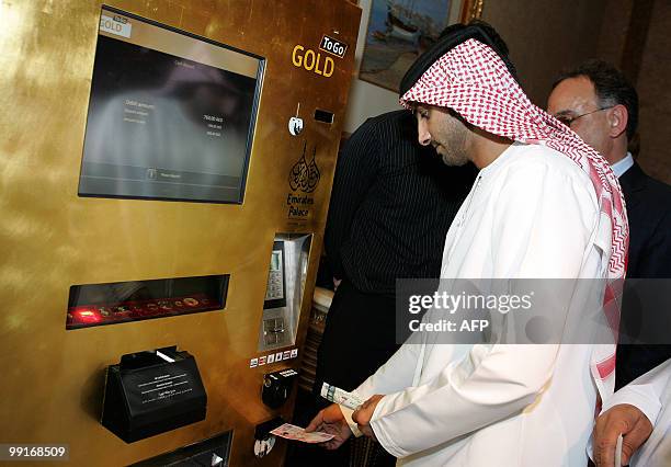 An Emirati man tries the "Gold to Go" vending machine at the Emirates Palace Hotel in Abu Dhabi on May 12, 2010. There's no mistaking what's in this...