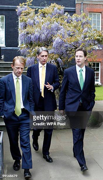 Treasury Secretary David Laws, Transport Secretary Philip Hammond and Deputy Prime Minister Nick Clegg walk into the garden of 10 Downing Street on...