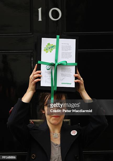 Greenpeace member Anna Jones holds a petition against the third runway at Heathrow airport outside 10 Downing Street on May 13, 2010 in London,...