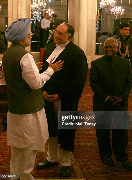 Prime Minister Manmohan Singh greets new Chief Justice of India Sarosh Homi Kapadia as his predecessor Justice K G Balakrishnan looks on during his...