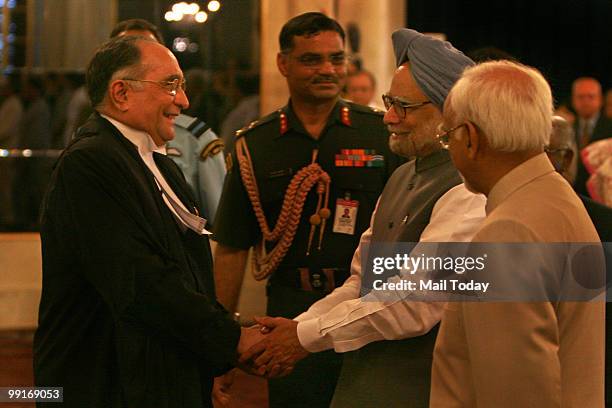 Prime Minister Manmohan Singh greets new Chief Justice of India Sarosh Homi Kapadia as Vice President Hamid Ansari looks on during his swearing-in...