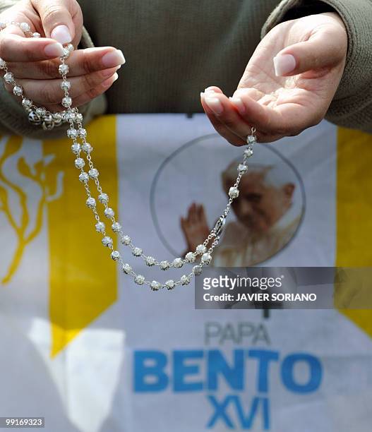 Pilgram holds a rosary during a mass celebrated by Pope Benedict XVI at the Fatima's Sanctuary, in Fatima, on May 13, 2010. Pope Benedict XVI began a...