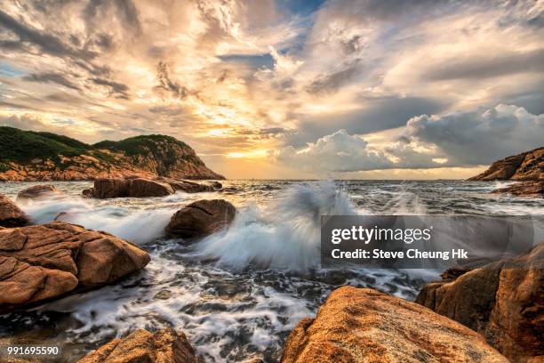 waves crashing over rocks on the coast. - hk landscape stock-fotos und bilder