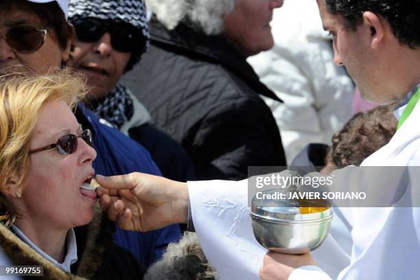 Priest gives the wafer to a pilgrim during a mass celebrated by Pope Benedict XVI at the Fatima's Sanctuary, in Fatima, on May 13, 2010. Pope...