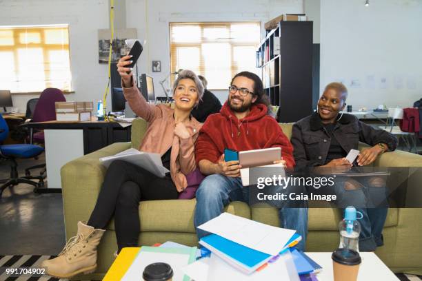 happy creative business people taking selfie in casual open plan office - open seat godo stock-fotos und bilder