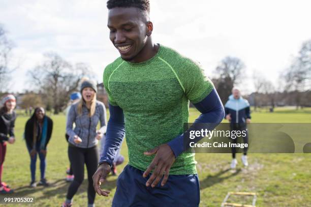 smiling man doing speed ladder drill in park - agility ladder ストックフォトと画像